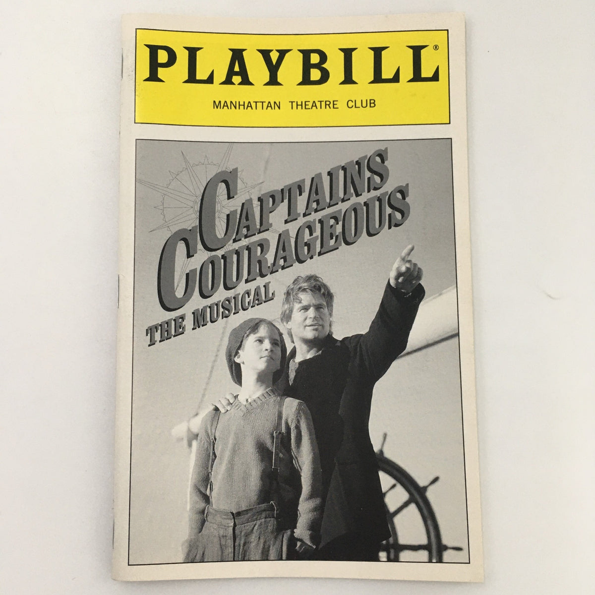 1999 Playbill for 'Captains Courageous' at Manhattan Theatre Club featuring a black and white cover image of a young boy and a man pointing, showcasing the theatrical production.