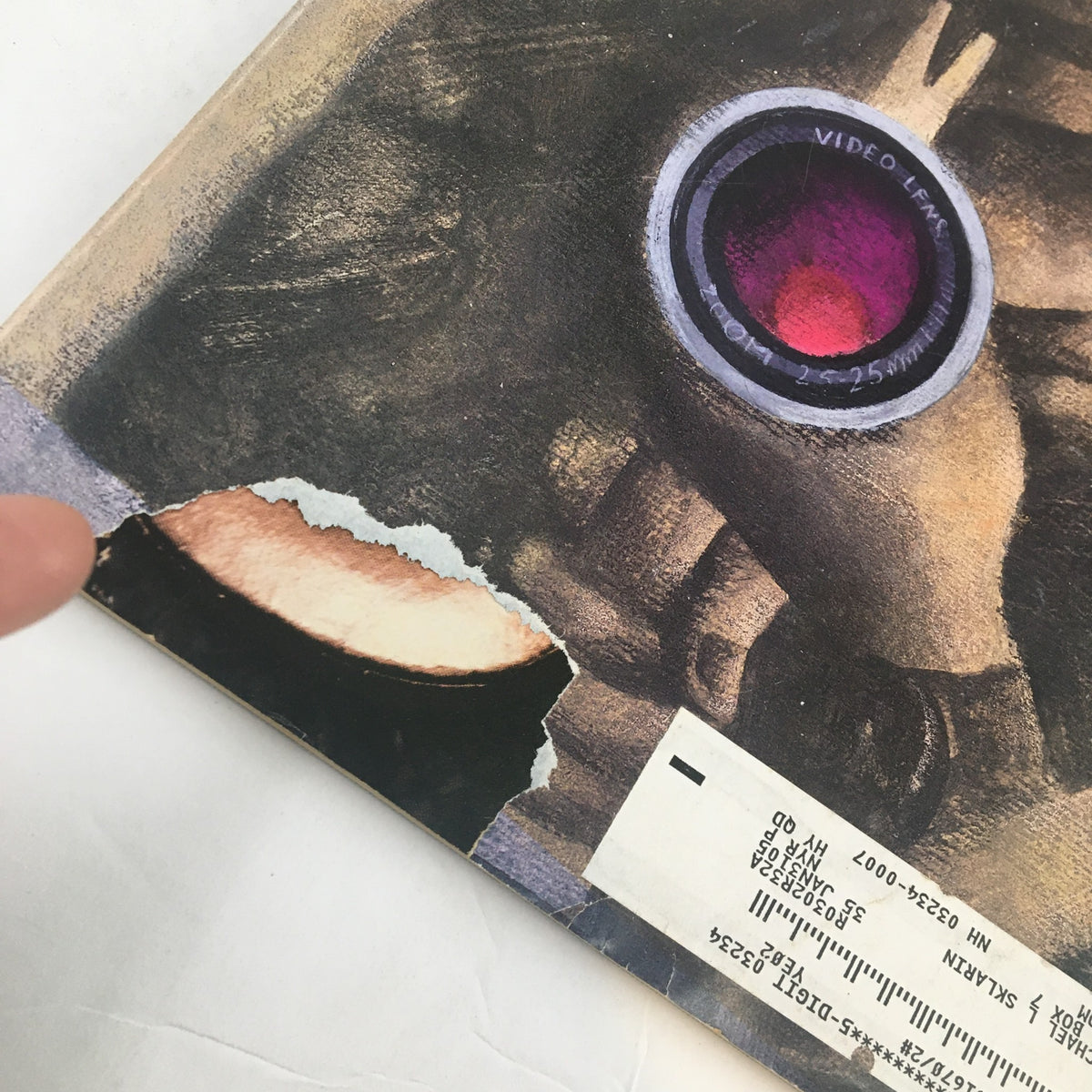 Close-up image of the bottom corner of The New Yorker Full Magazine April 14 2003 Action by Ana Juan depicting a larger tear and the cover's edge.