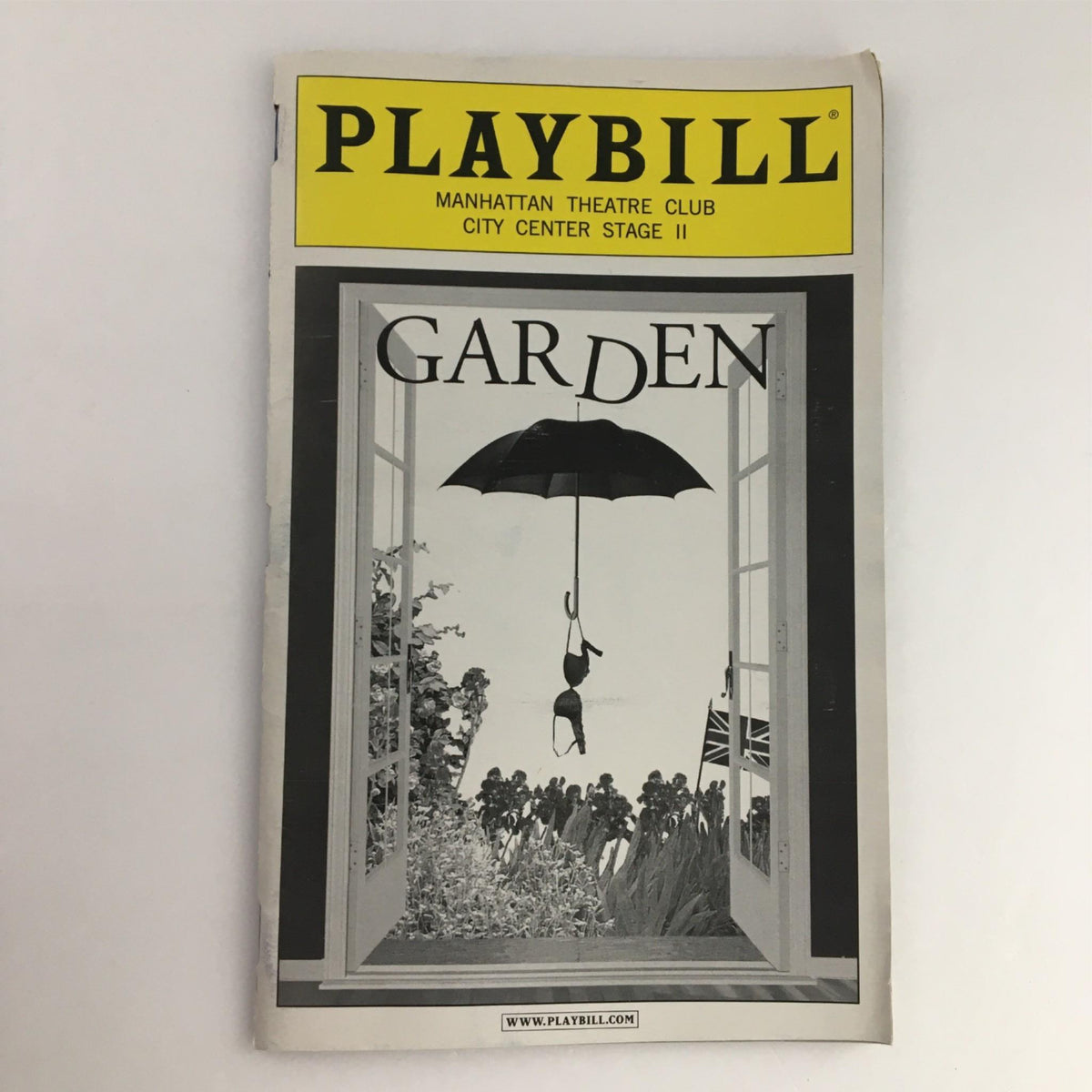 2002 Playbill for 'Garden' by Manhattan Theater Club at City Center Stage II showcasing a dramatic cover design with an umbrella and window motif.