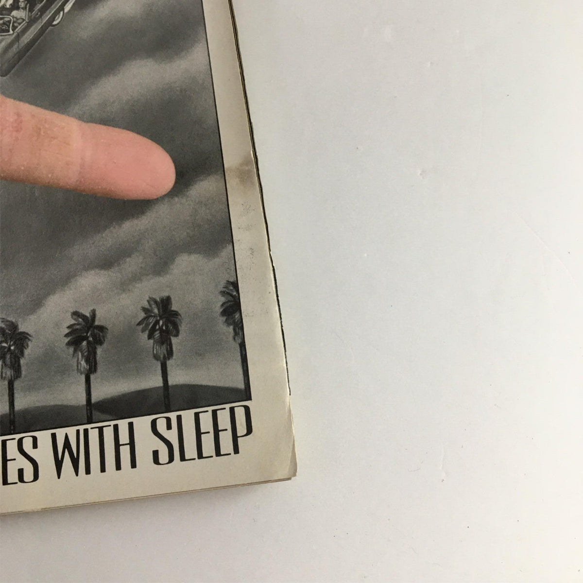 Close-up of the 1990 Playbill for 'Each Day Dies with Sleep' showing the cover design with palm trees and a car, highlighting its collectible nature.