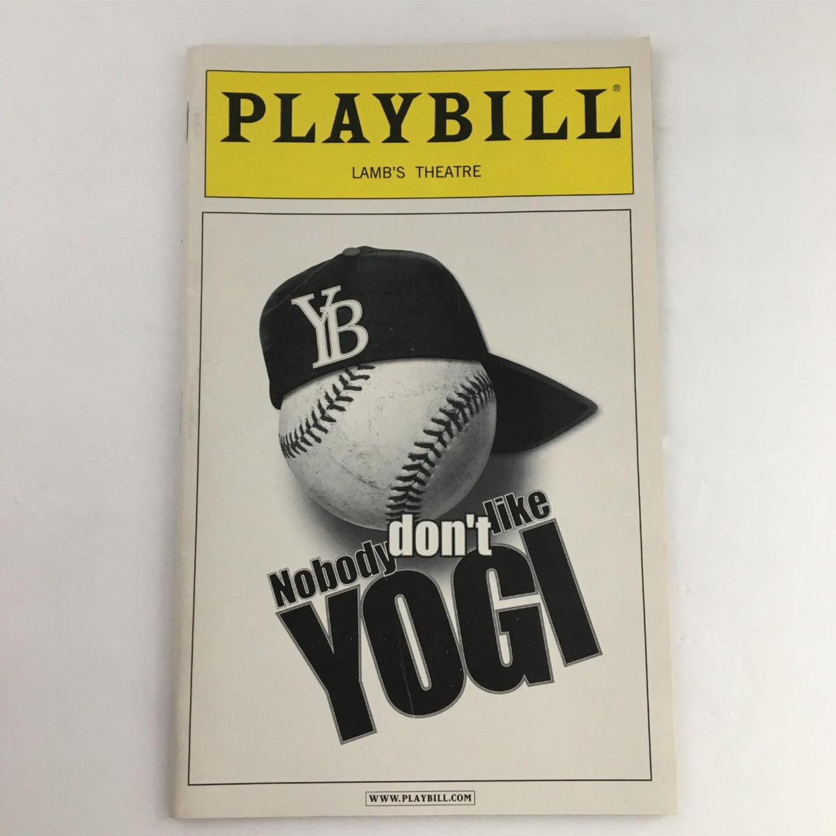 2003 Playbill for 'Nobody Don't Like Yogi' featuring a baseball cap and a baseball design, representing the artistic production at Lamb's Theatre.