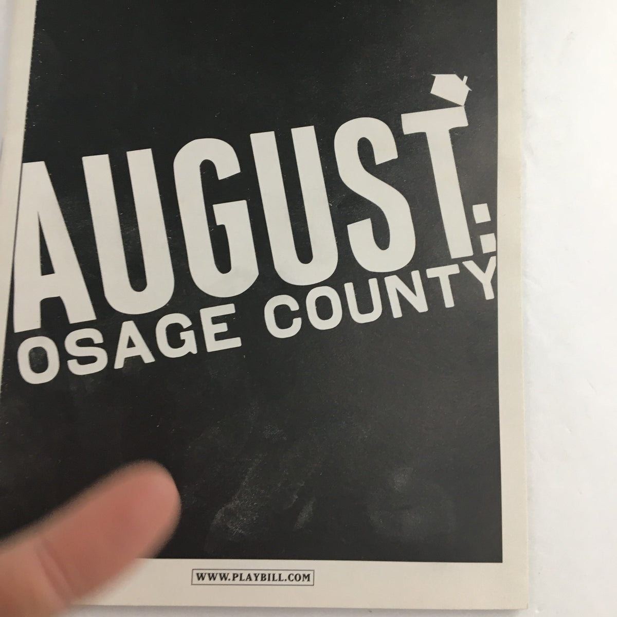 Close-up of the 2008 Playbill for August Osage County, highlighting the title and details on the cover.