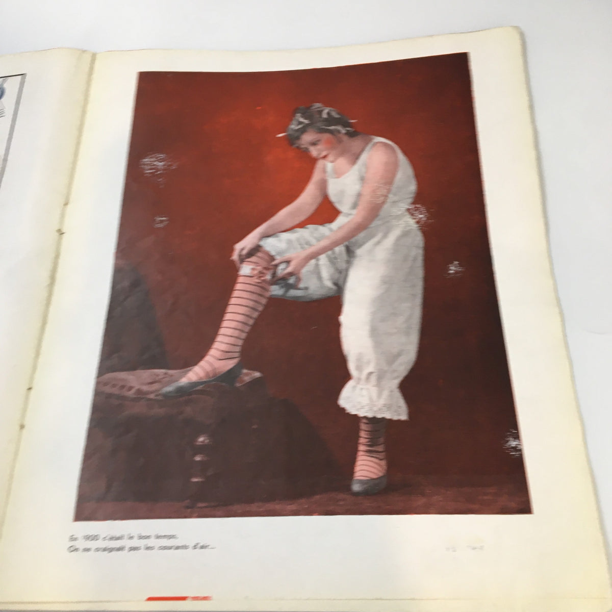 Inside page of VTG Pages Folles Magazine January 1936 displaying a colored photo of a woman dressing in vintage attire, highlighting fashion trends of the era.