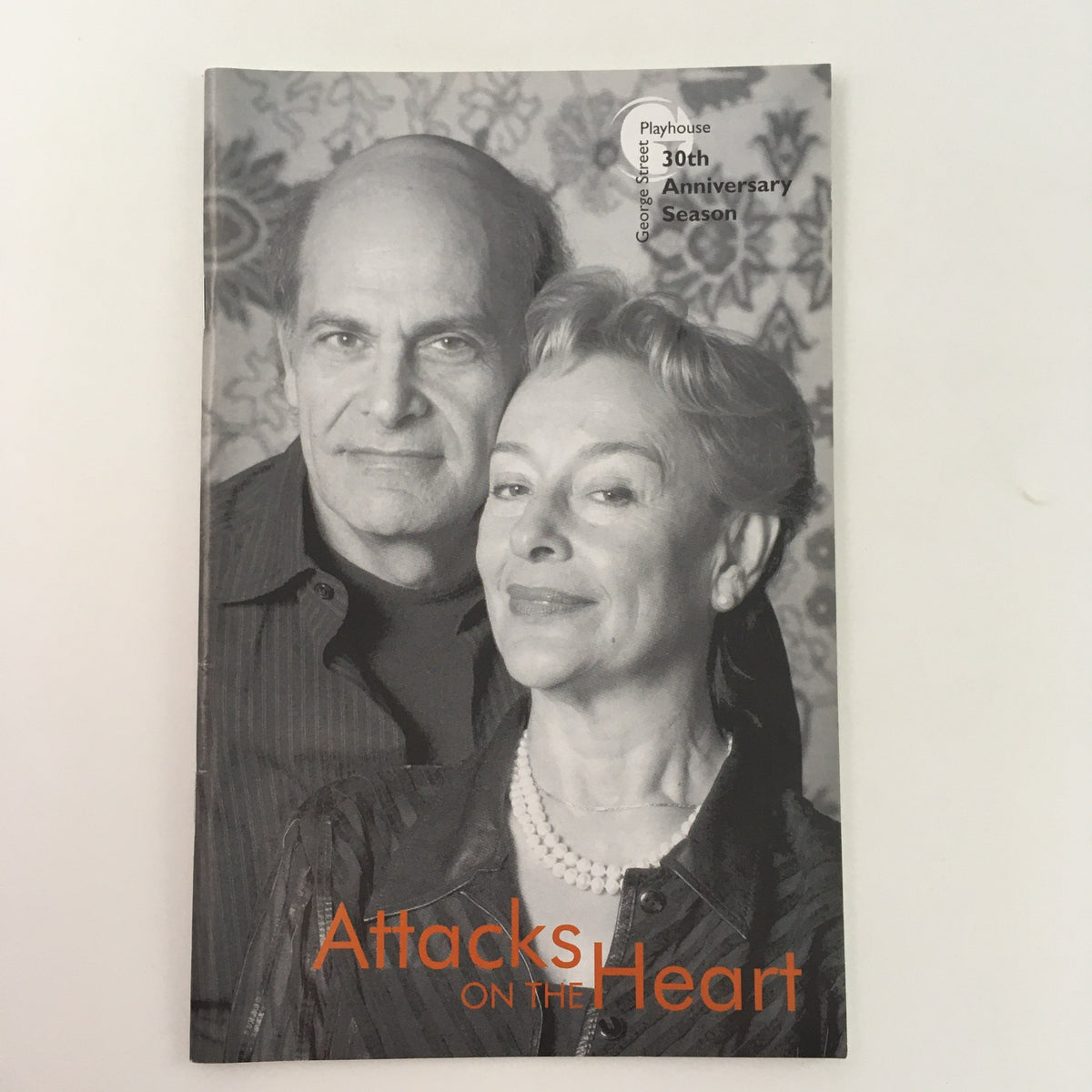 Cover of 'Attacks on the Heart' by Arthur Laurents at George Street Playhouse, featuring two actors posing against a patterned background.