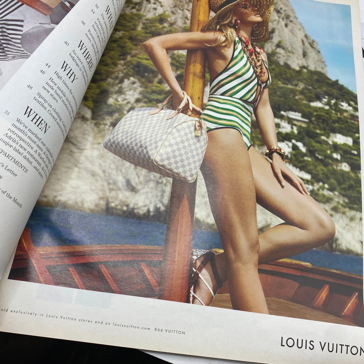 Interior page from W Magazine January 2011, showcasing a vibrant fashion spread with a model in a striped swimsuit against a scenic backdrop, emphasizing luxury fashion themes.