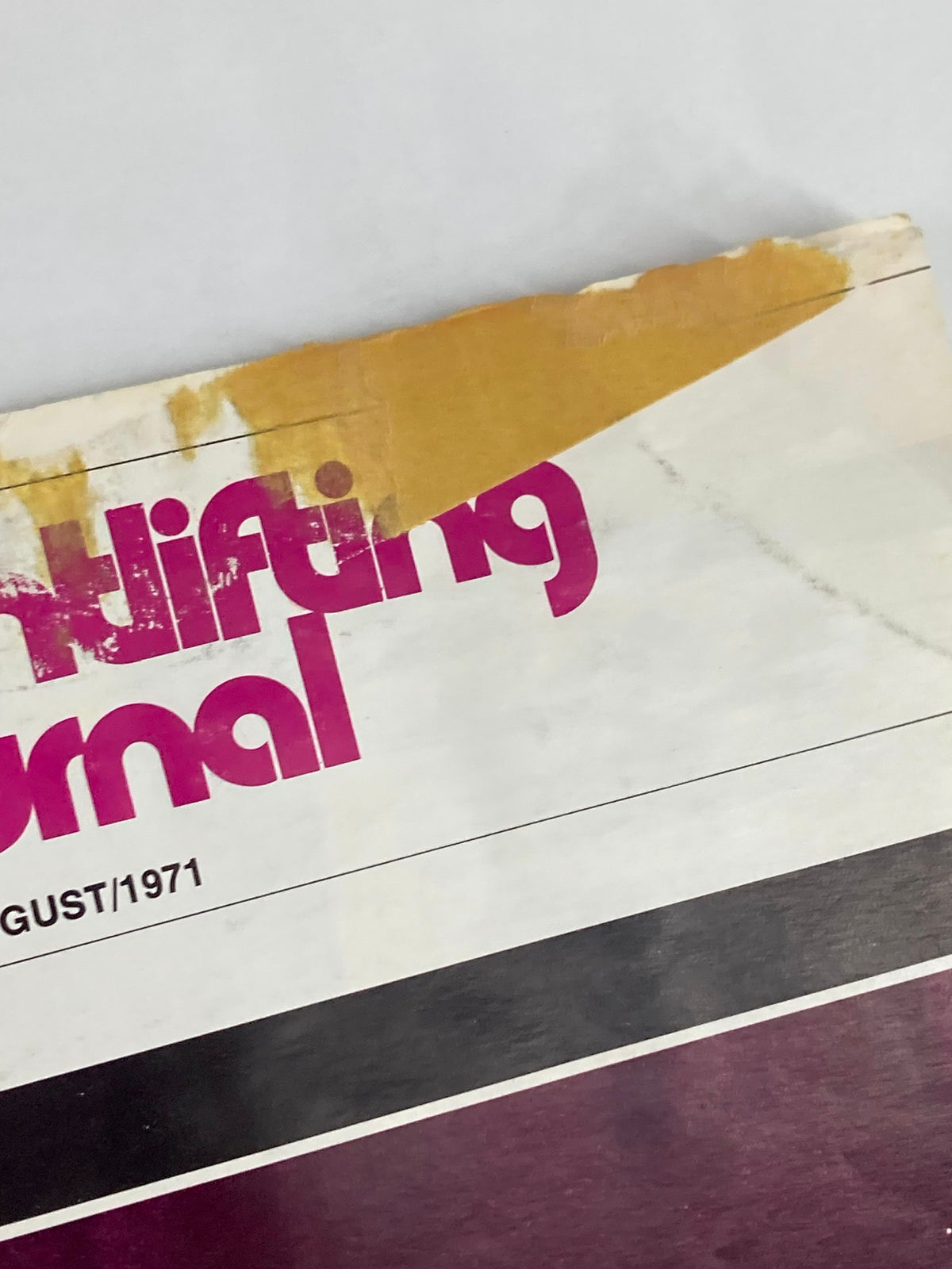 Close-up view of the damaged cover of the VTG Weightlifting Journal Magazine August 1971, highlighting age-worn details.