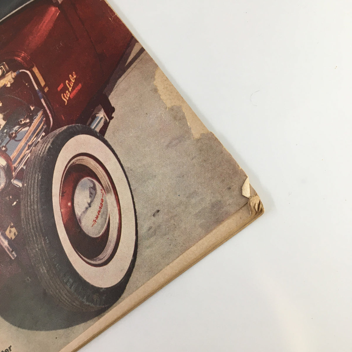 Close-up of the binding and the wheel of the vintage car on the cover of VTG Hot Rod Magazine March 1953.