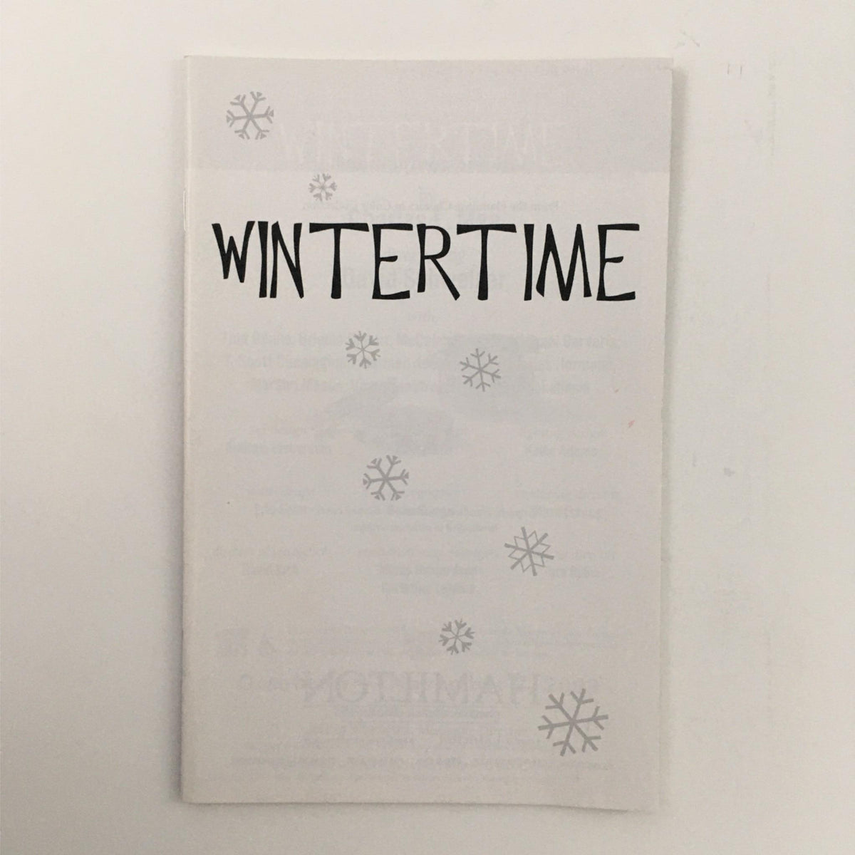 Cover of 'Wintertime' by Charles Mee featuring bold title and snowflake design, performed at McCarter Theatre Center.