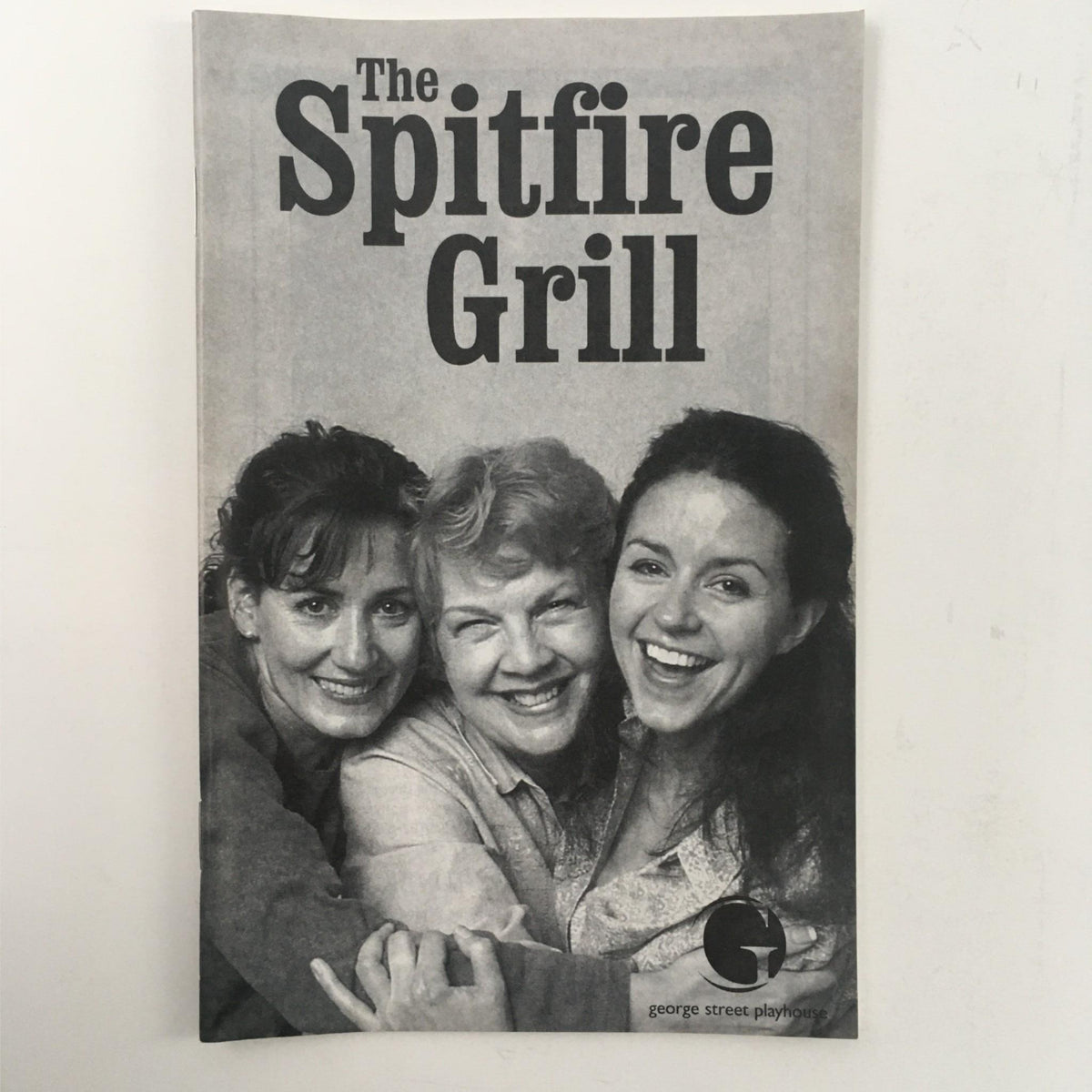 Cover of the 2000 The Spitfire Grill by James Valcq and David Saint at George Street Playhouse, featuring three smiling women in black and white.
