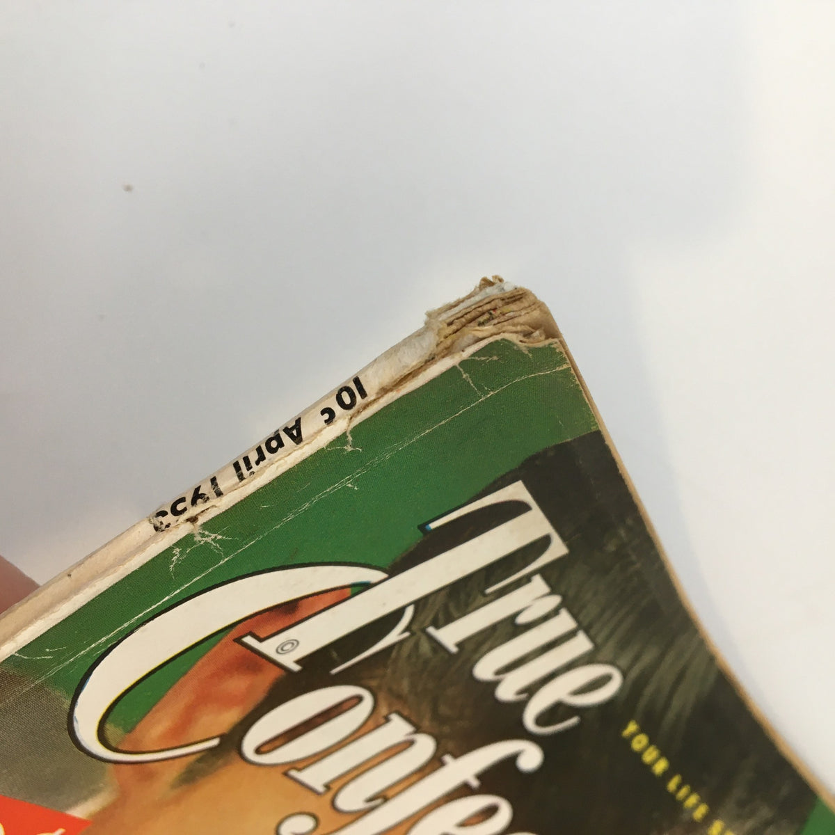 Close-up view of the corner of the True Confessions Magazine April 1953, showcasing the spine and publication date with minor wear details.
