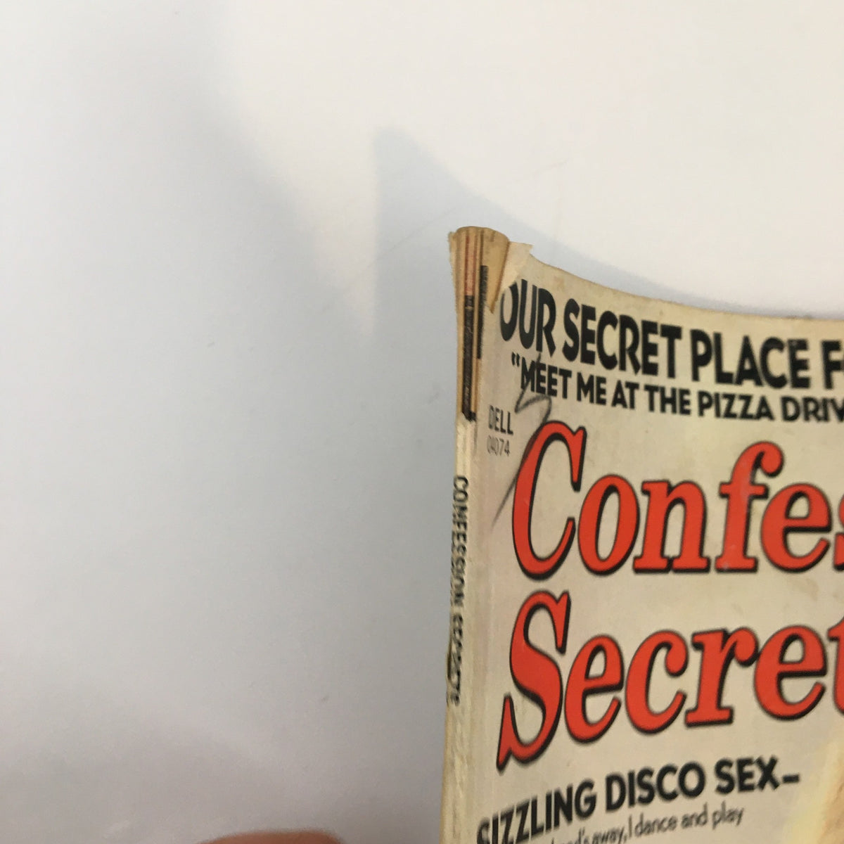 Side view of VTG Confession Secrets Magazine August 1979 displaying the title on the spine and text about a secret meeting place for teen gatherings.