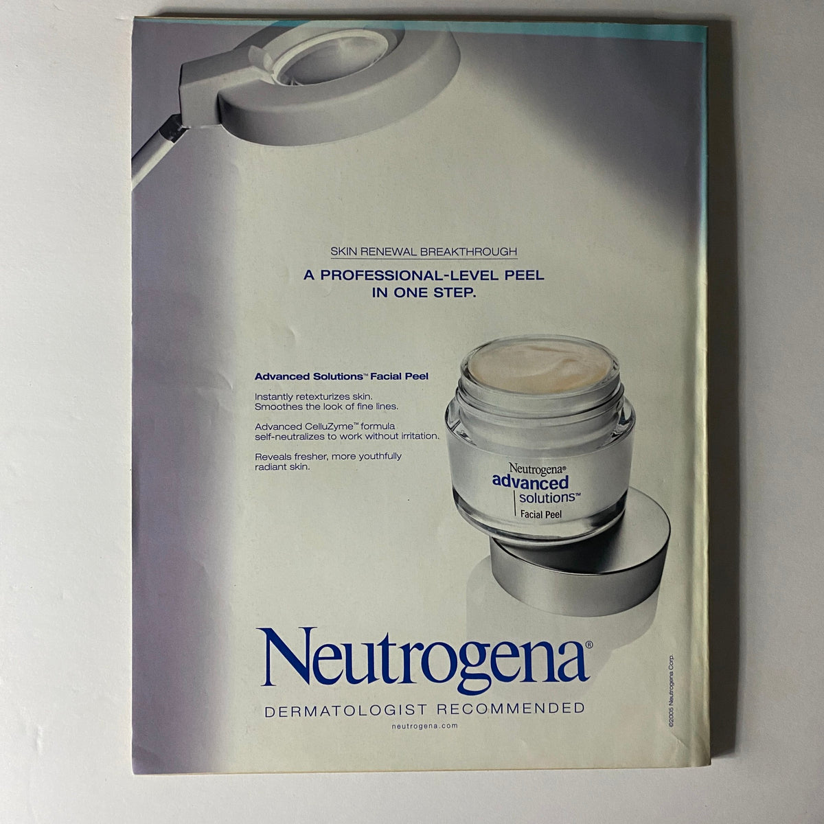 W Magazine July 2005 ad for Neutrogena highlighting the Advanced Solutions Facial Peel with a professional magnifying lamp, promoting skincare innovation and dermatological recommendations.