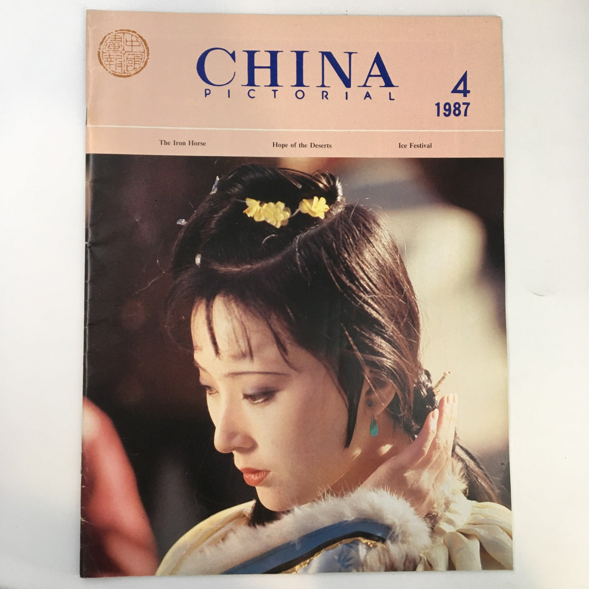 Cover of VTG China Pictorial Magazine April 1987 titled 'Hope of the Deserts,' showcasing a woman with traditional hairstyle adorned with flowers, reflecting the cultural aesthetics of China in the late 20th century.