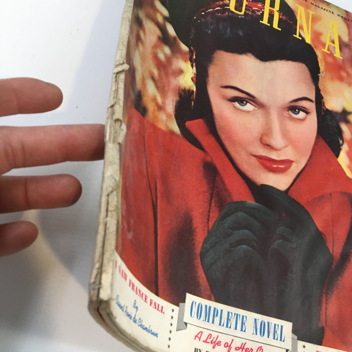Cover of Ladies Home Journal Magazine November 1910 featuring a woman in a red coat and gloves, highlighting articles like 'A Life of Her Own' and 'How America Lives'.