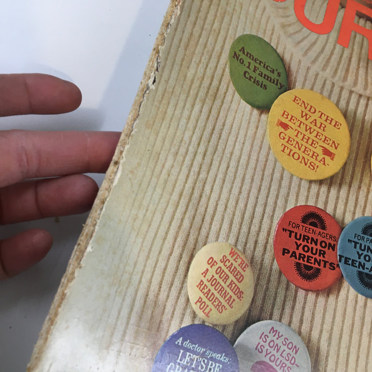 Close-up of Ladies' Home Journal Magazine January 1968 cover showing colorful buttons discussing generational issues and concerns about children's well-being, emphasizing the theme of family dynamics.