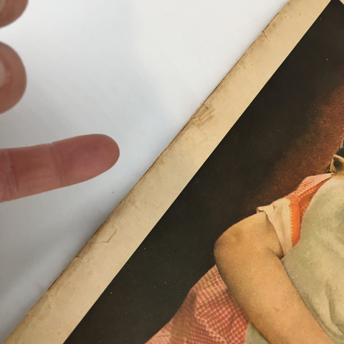 Close-up of a finger pointing at the edge of the VTG Household Magazine August 1936 cover, showcasing wear that adds to its vintage charm.