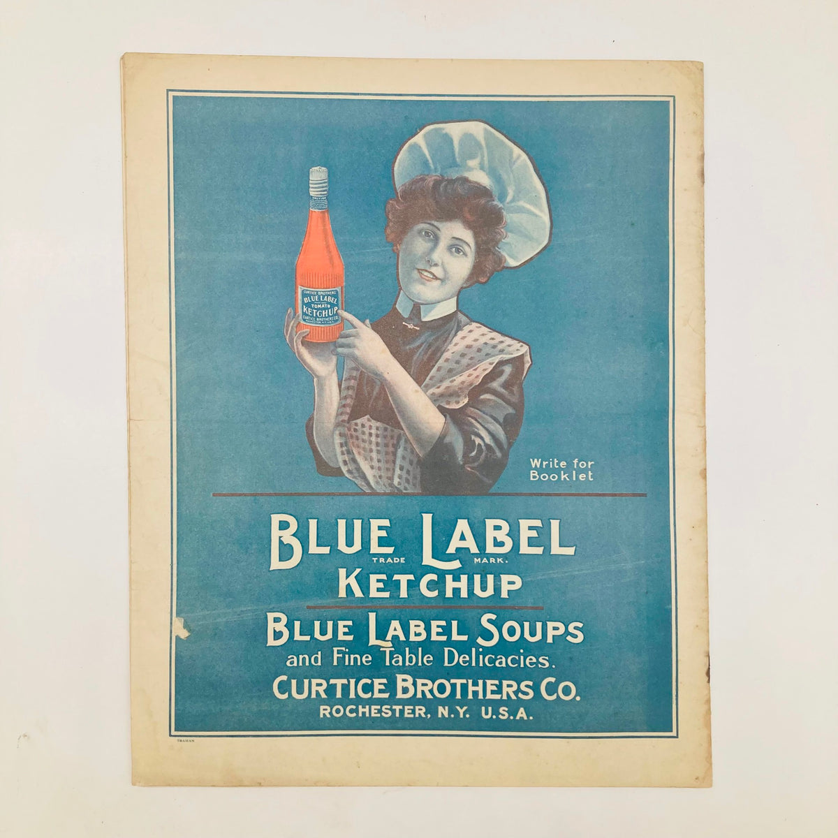 Vintage advertisement featuring a woman in a chef's hat holding a bottle of Blue Label Ketchup, promoting Blue Label Soups and Table Delicacies, with the title 'Blue Label Ketchup'.