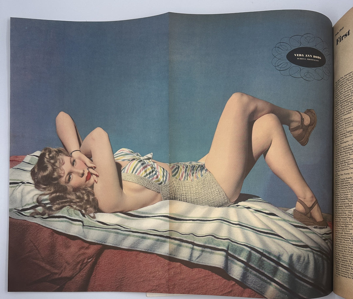 Vintage Esquire Magazine July 1942 featuring Varga pinup model Veda Ann Borg lounging in a stylish swimsuit against a blue backdrop.