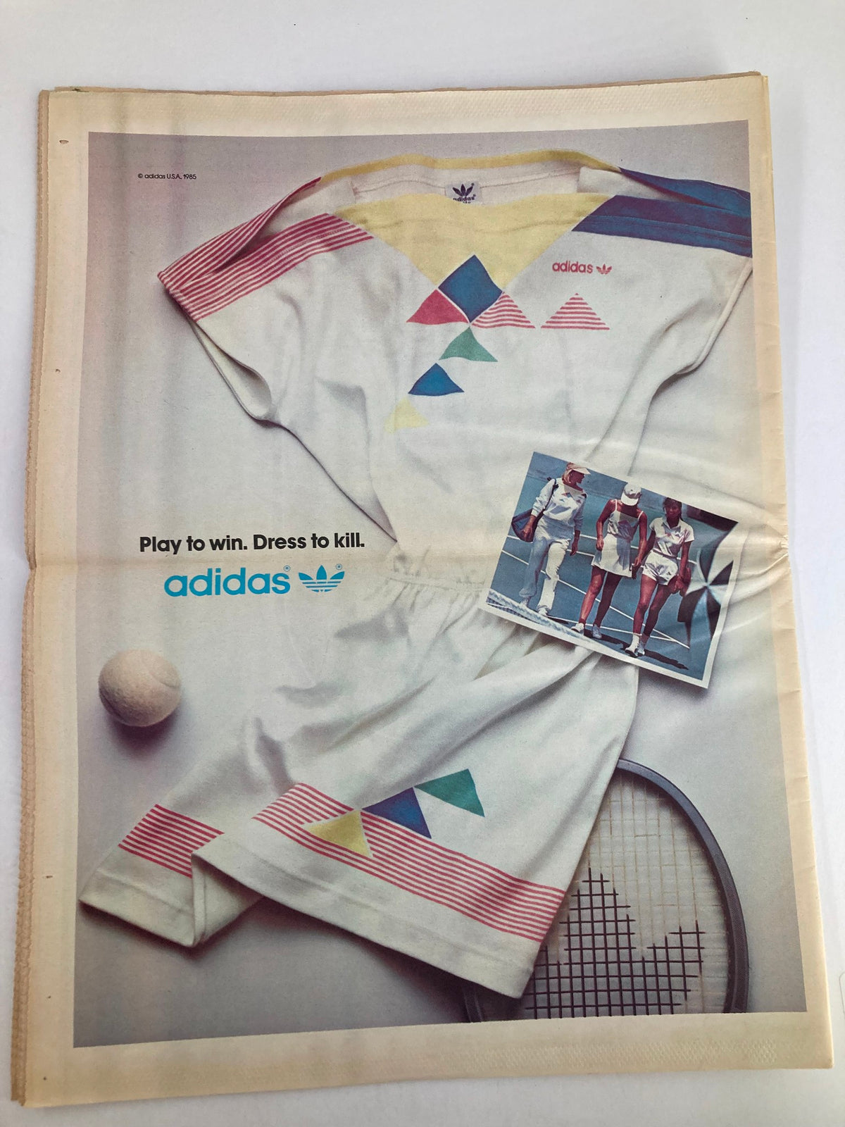 Advertisement in the VTG Inside Tennis Magazine October 1985 for Adidas tennis apparel, displaying stylish sportswear, a tennis ball, and a background of a tennis racket.