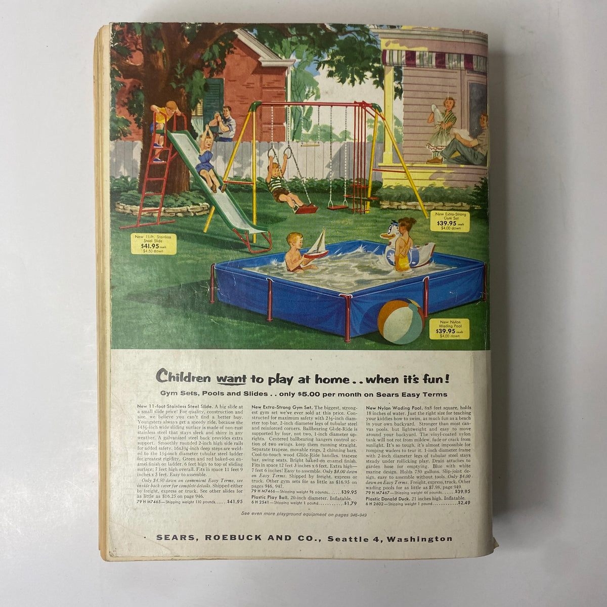 Back cover illustration from the 1956 Sears Roebuck and Co. Spring and Summer Catalog, depicting children playing outdoors with playground equipment, emphasizing family fun.