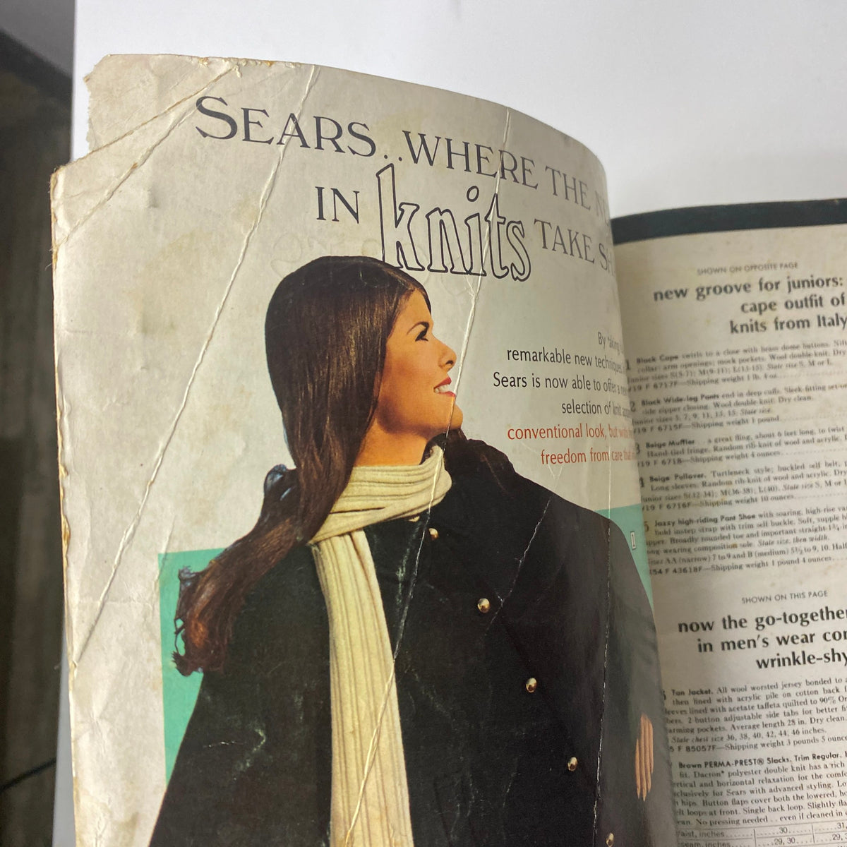 Interior page of the 1969 Sears Fall and Winter Catalog showcasing a model in a stylish coat and a scarf with the caption discussing knit selections.