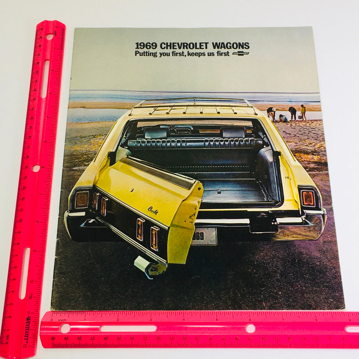 1969 Chevrolet Kingswood Estate Wagons Dealership Car Auto Brochure Catalog featuring the rear view of a Chevrolet wagon with the tailgate open, demonstrating practical design and spacious interior.