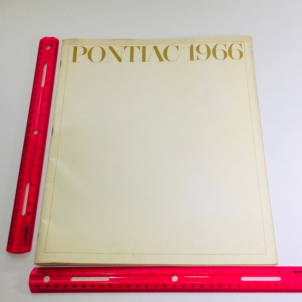 Cover of the 1966 Pontiac Brougham Specifications Dealership Car Auto Brochure Catalog, featuring a simple design and a ruler for size reference.