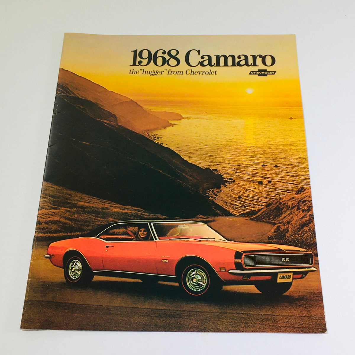 1968 Chevrolet Camaro Showroom Brochure Cover featuring a stunning orange Camaro SS by the ocean at sunset.