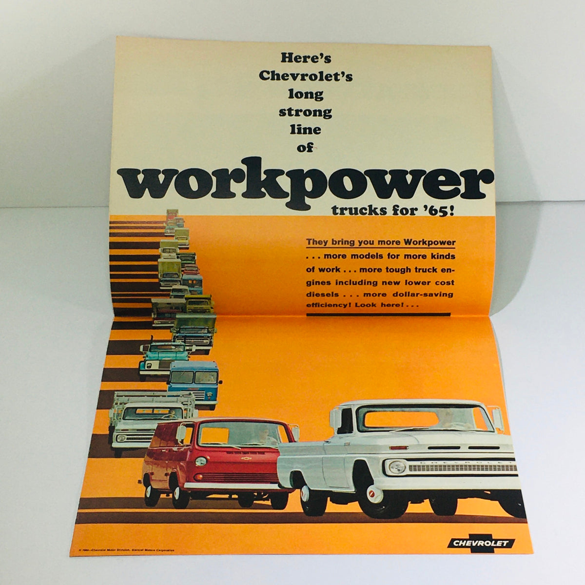 Cover of the 1965 Chevrolet Full-Line Truck Selector Dealership Car Auto Brochure showcasing various Chevy trucks, highlighting the tagline 'Here’s Chevrolet’s long strong line of workpower trucks for ’65!'.