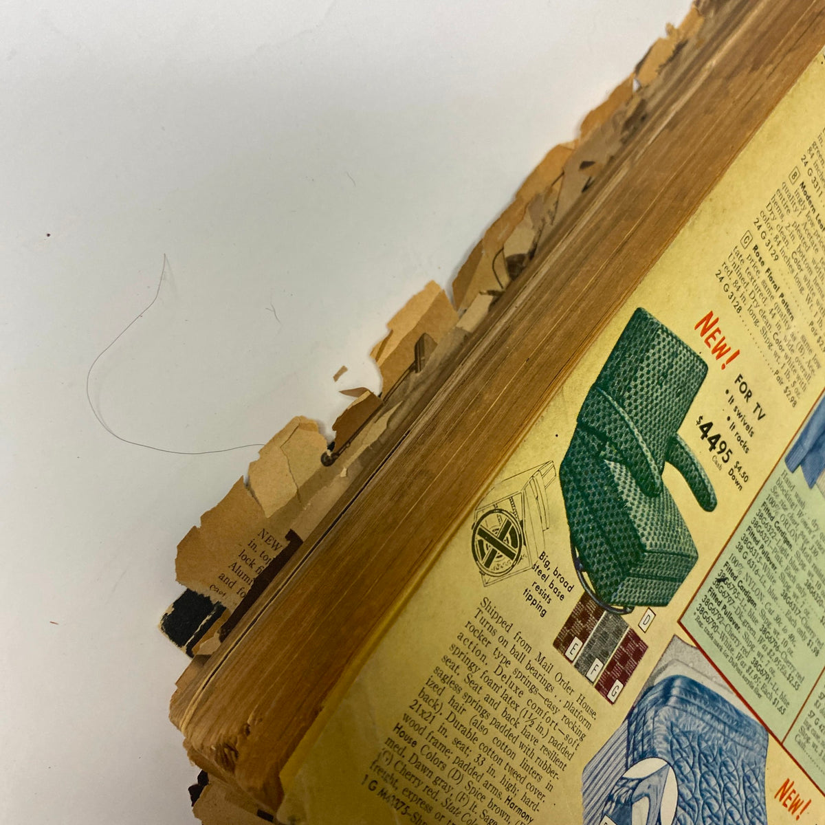 Close-up view of the back cover page of the 1954 Sears Roebuck and Co. Fall and Winter Catalog, highlighting a chair and a sleeping bag with visible edge damage.