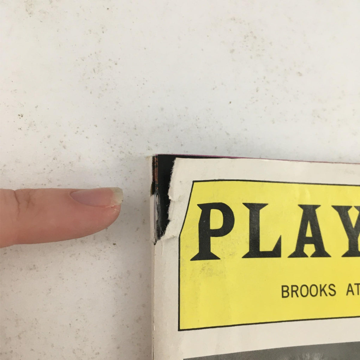 Close-up of a damaged corner of the 1996 Playbill for 'Taking Sides,' showing minor wear consistent with age.