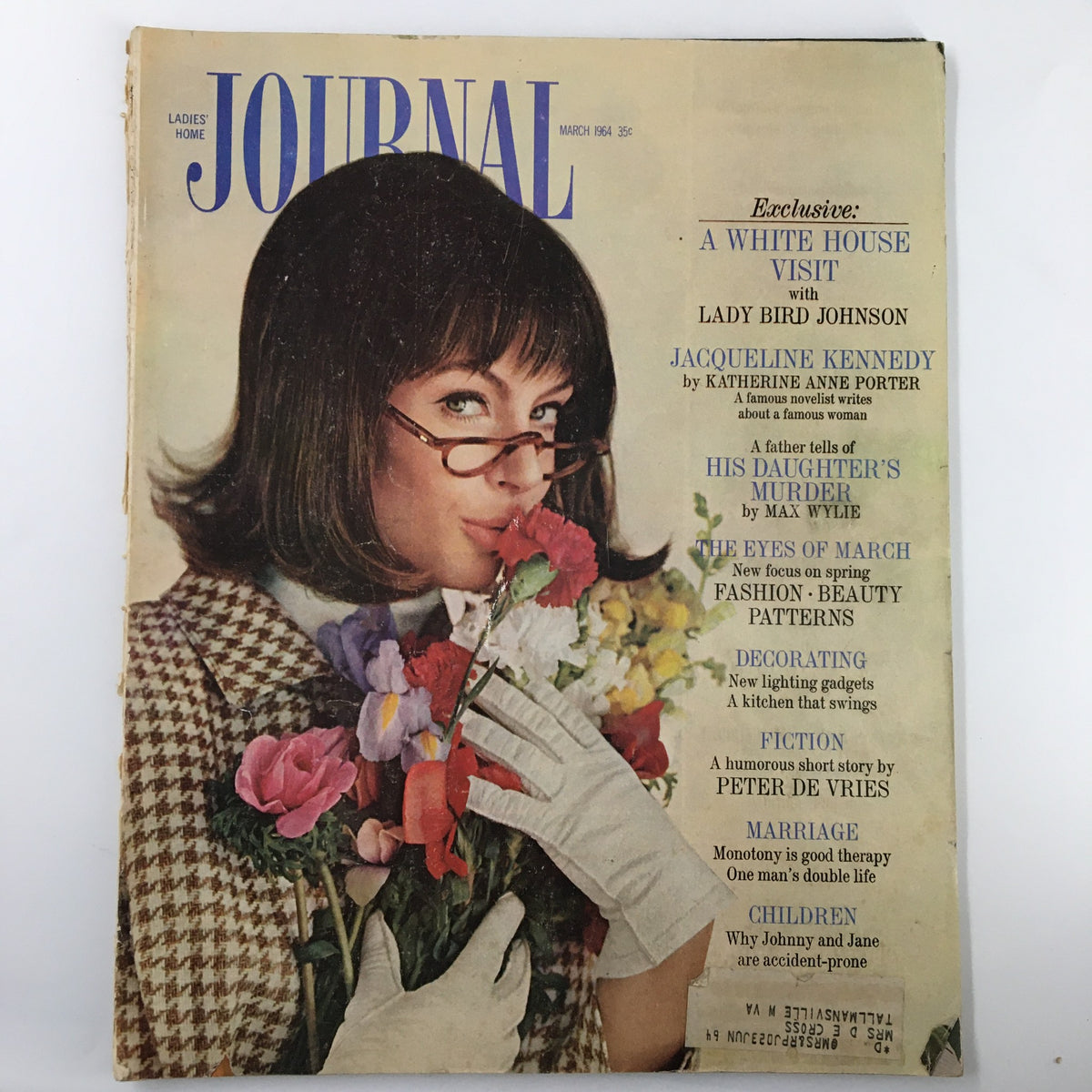 Cover of Ladies' Home Journal Magazine March 1964 featuring a woman in glasses holding flowers, highlighting Lady Bird Johnson and Jackie Kennedy.