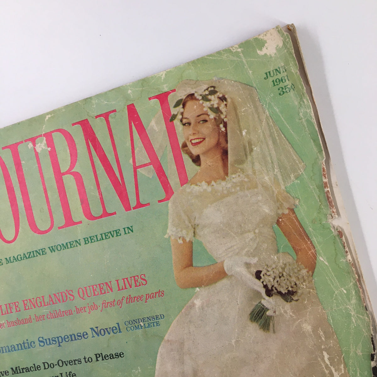Detailed shot of the Ladies' Home Journal Magazine June 1961 cover, featuring a bride holding a bouquet, emphasizing the issue's theme 'The Life England's Queen Lives'.