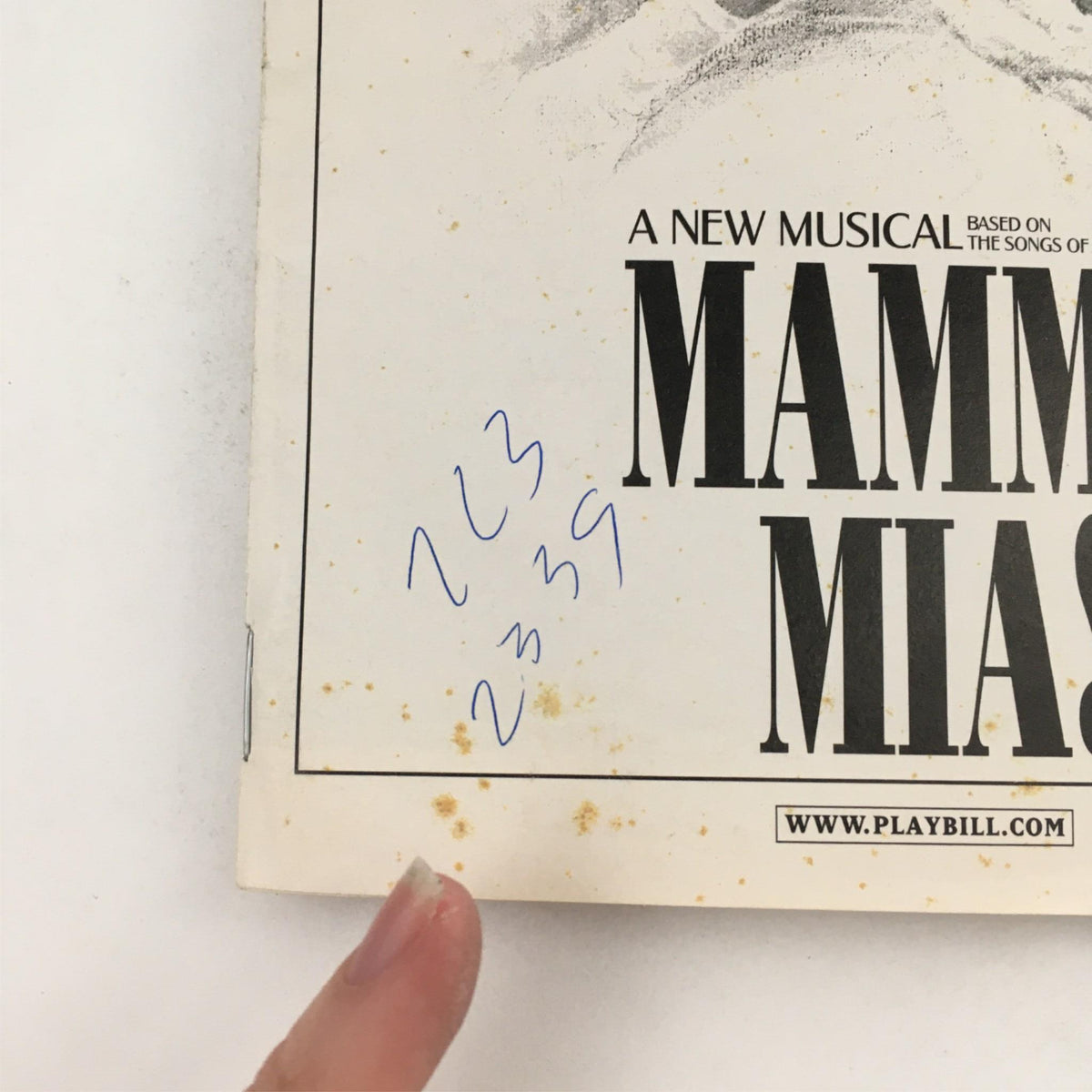 Close-up of the back cover of the 2002 Playbill Mamma Mia! with handwritten numbers and stains, showcasing its vintage condition.