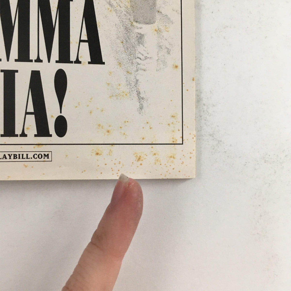 Detailed view of the corner of the 2002 Playbill Mamma Mia! showing marks and wear, emphasizing its collectible status.
