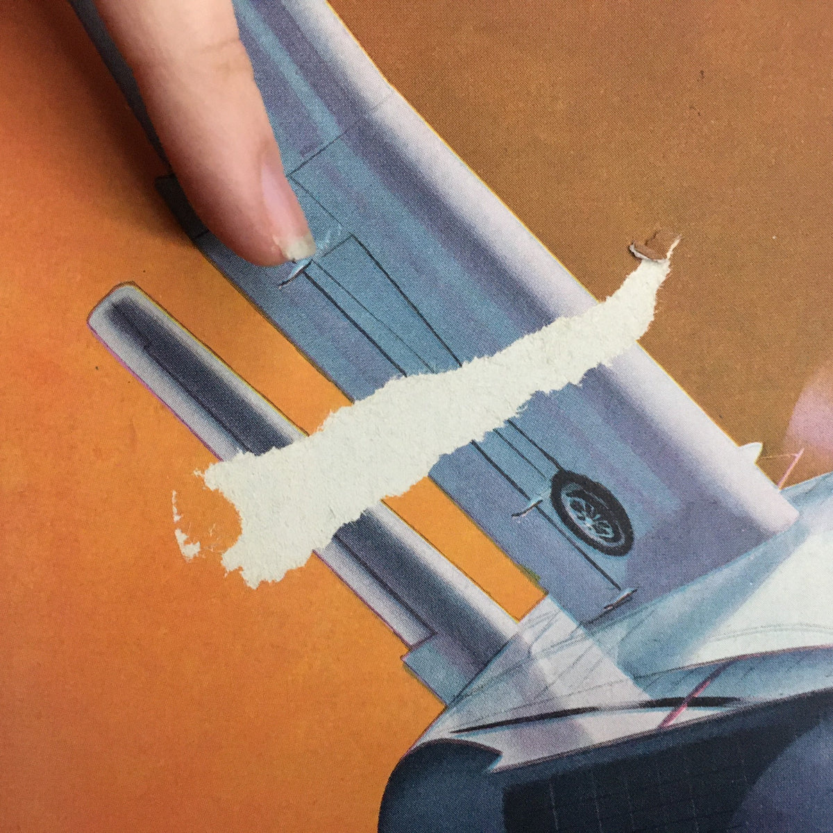 Close-up detail of the cover damage on Model Airplane News Magazine - April 1947, showing paper tearing near the aircraft illustration.