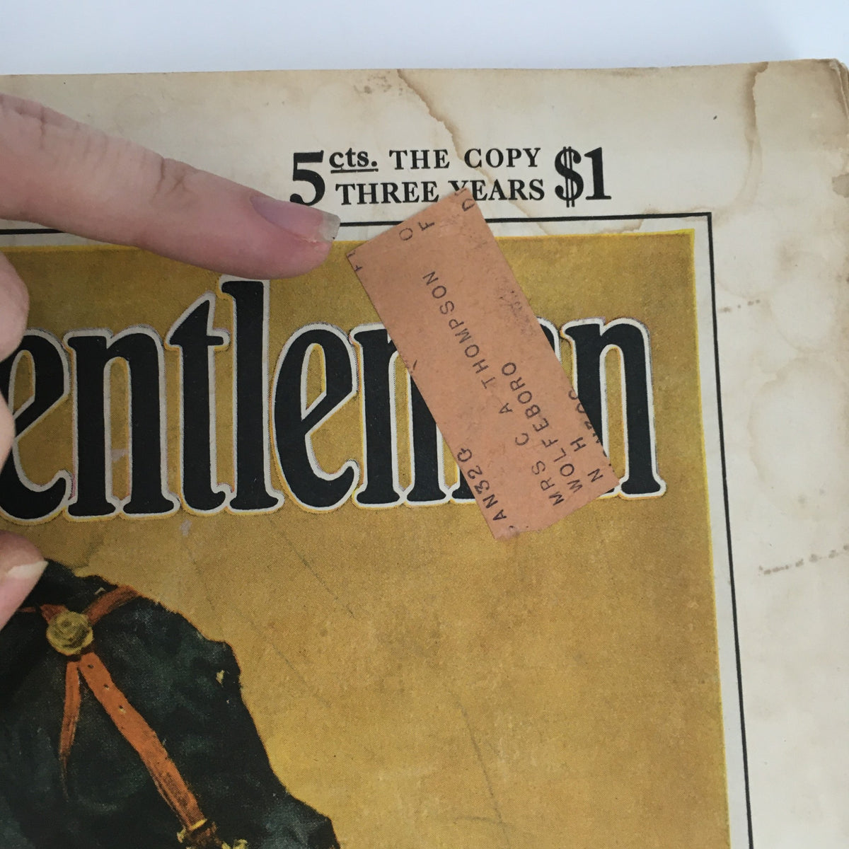 Close-up view of The Country Gentleman Magazine January 1930, showcasing the cover with a finger pointing towards the pricing details, highlighting the vintage character of this historical publication.