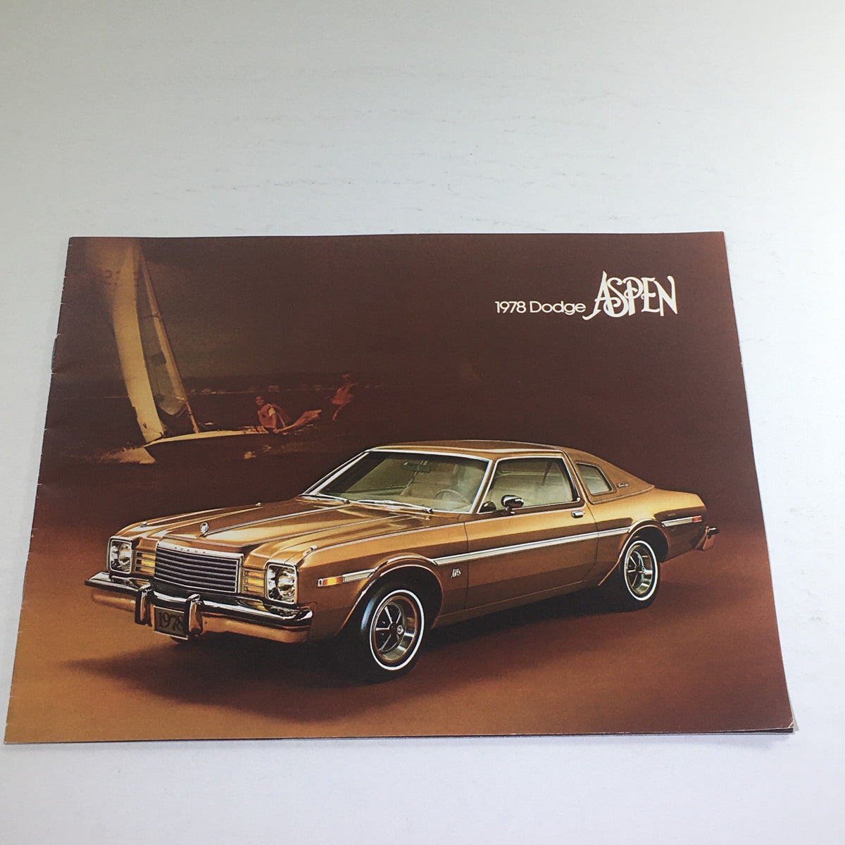1978 Dodge Aspen Special Edition Paint Dealership Car Auto Brochure Catalog featuring a sleek gold vehicle on a stylish backdrop, showcasing its iconic design and classic features.