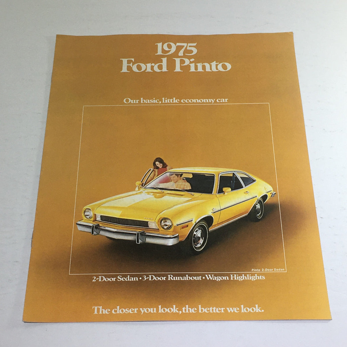 1975 Ford Pinto Sedan brochure showcasing the bright yellow car with a couple, highlighting its economy car features. This image is part of the 1975 Ford Pinto Sedan/Wagon/Runabout Dealership Car Auto Brochure Catalog.