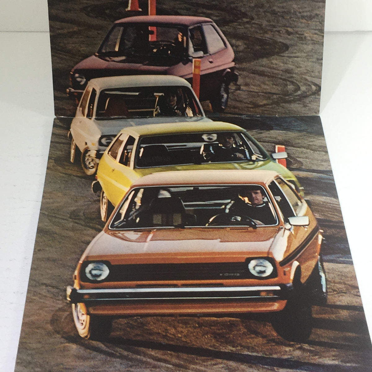 1976 Ford Fiesta 3-Door Hatchback Dealership Car Auto Brochure Catalog featuring multiple colorful Ford Fiesta models on a racetrack.