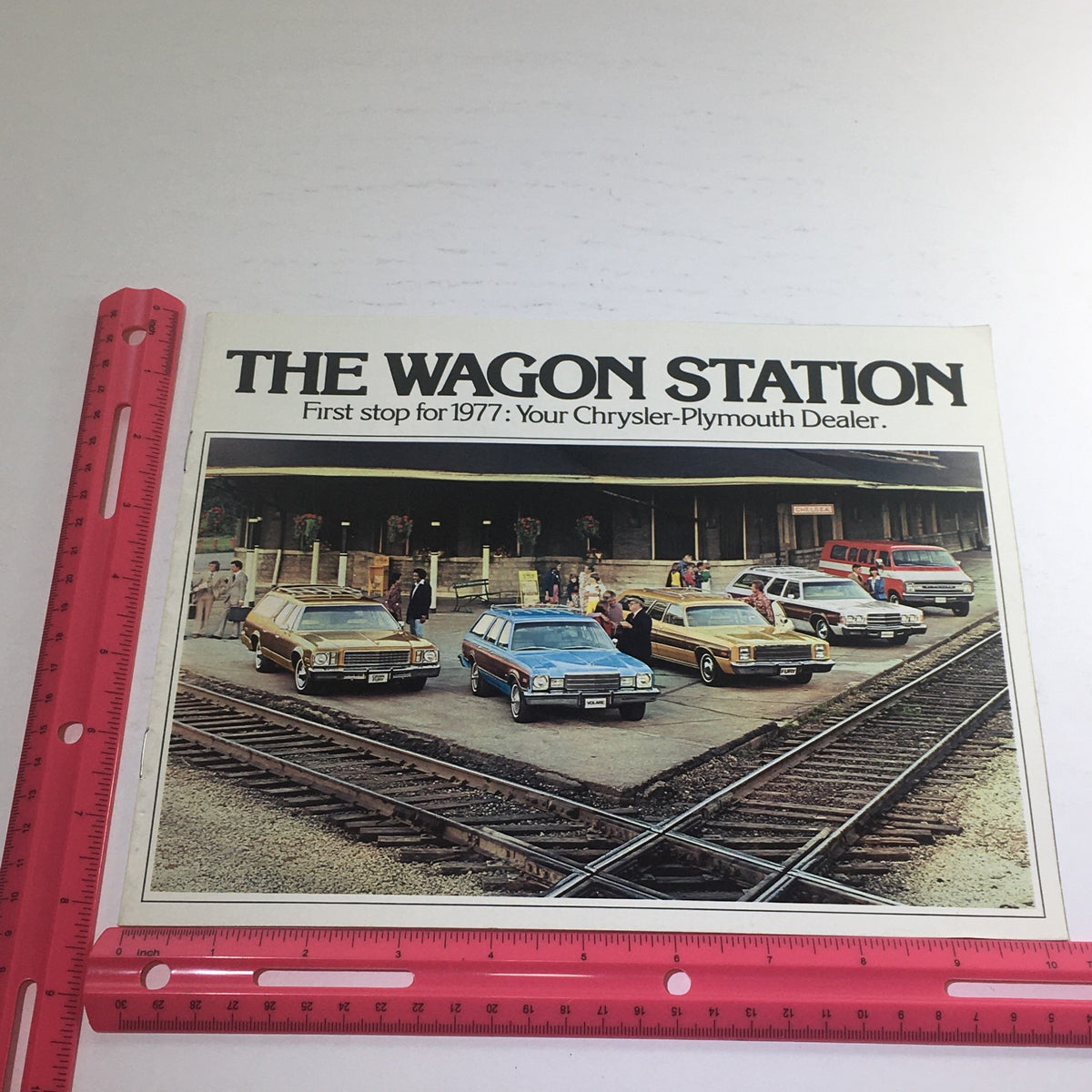 1977 Chrysler-Plymouth Wagon Station Dealership Sale Car Auto Brochure Catalog with measurement scale, displaying a lineup of Chrysler-Plymouth Wagon models at a dealership.