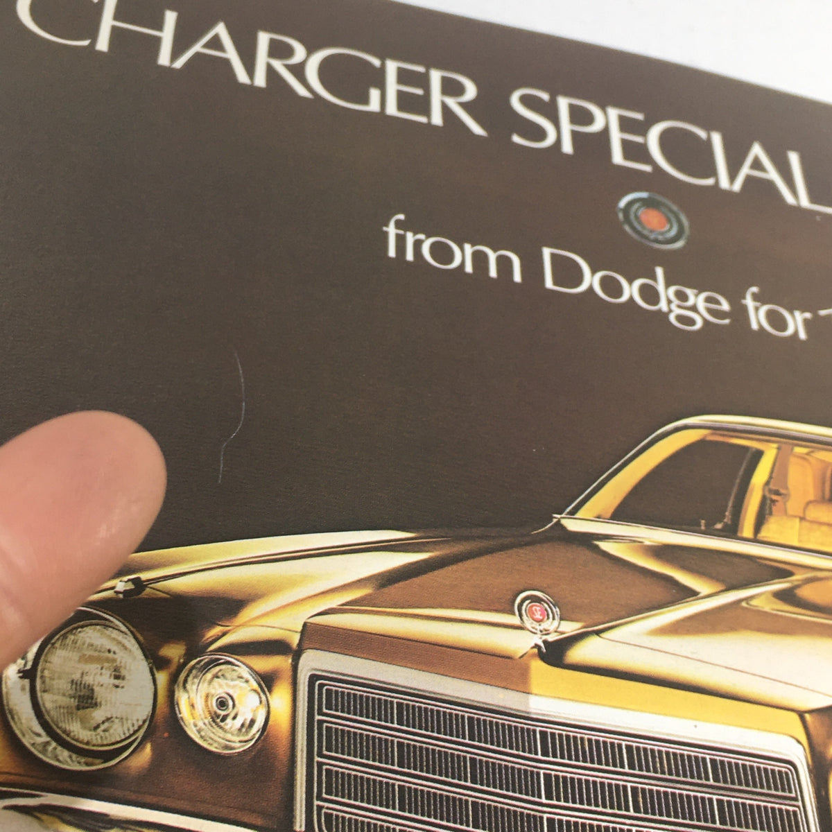 Close-up of the 1975 Dodge Charger Special Edition Dealership Car Auto Brochure Catalog showcasing details of the car's front grille and styling.