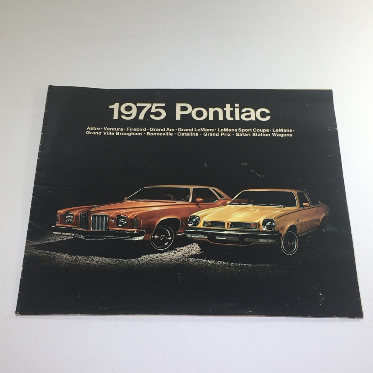 Cover of the 1975 Pontiac Astre/Ventura/Firebird Wagons Dealership Car Auto Brochure Catalog featuring two classic Pontiac vehicles.