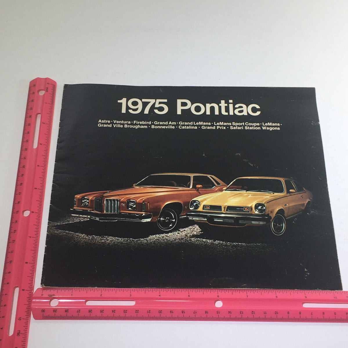1975 Pontiac Astre, Ventura, Firebird Wagons Dealership Car Auto Brochure Catalog showcasing vintage Pontiac vehicles in a dramatic display.