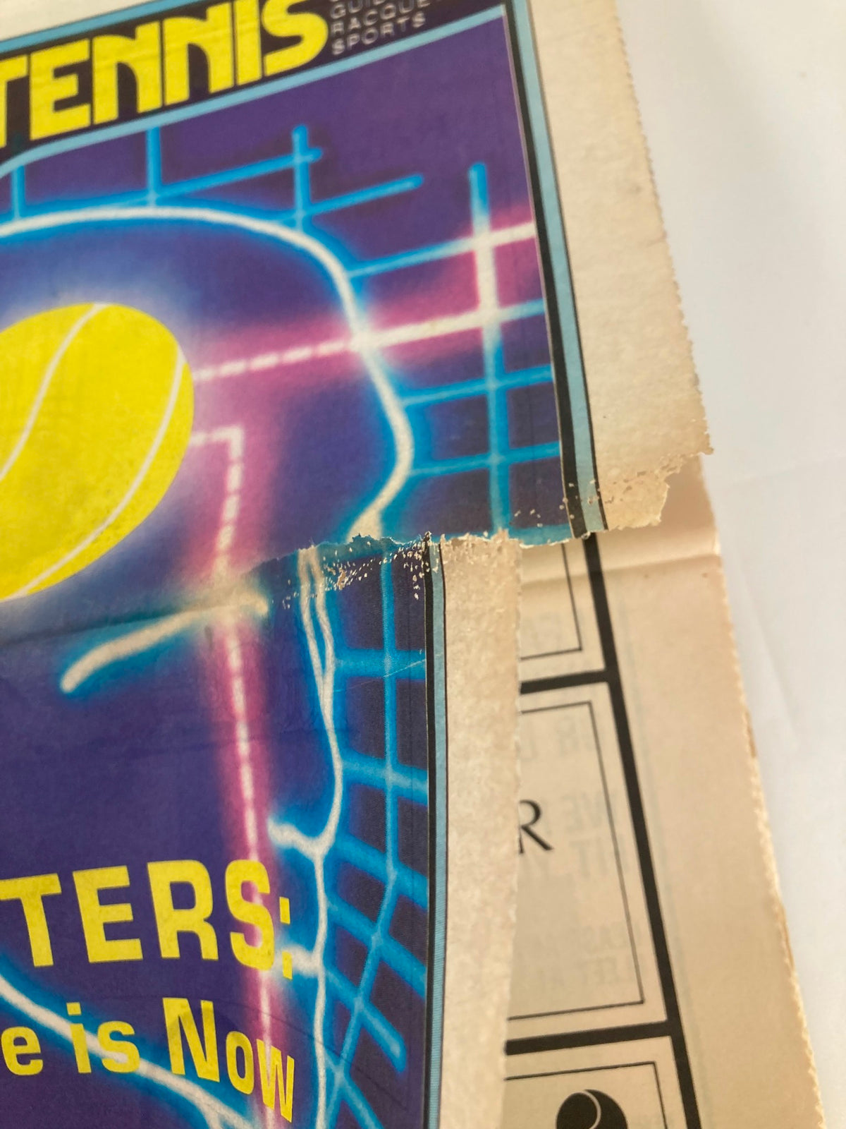 Close-up of the corner of the May 1983 issue of Inside Tennis Magazine featuring the title 'Computer's The Future is Now'. Highlights the magazine's worn edge and vibrant cover with a graphic of a tennis ball.
