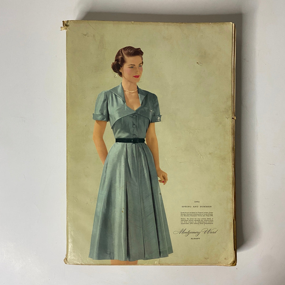 Alternate view of the 1952 Montgomery Ward Albany Spring and Summer Catalog cover showcasing a woman in a classic blue dress, highlighting mid-20th century style.