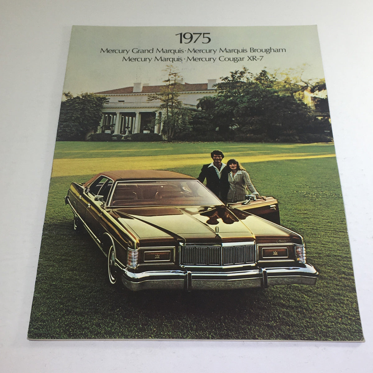 Cover of the 1975 Ford Mercury Grand Marquis/Cougar XR-7 Dealership Car Auto Brochure Catalog featuring a vintage car and a couple in an outdoor setting.