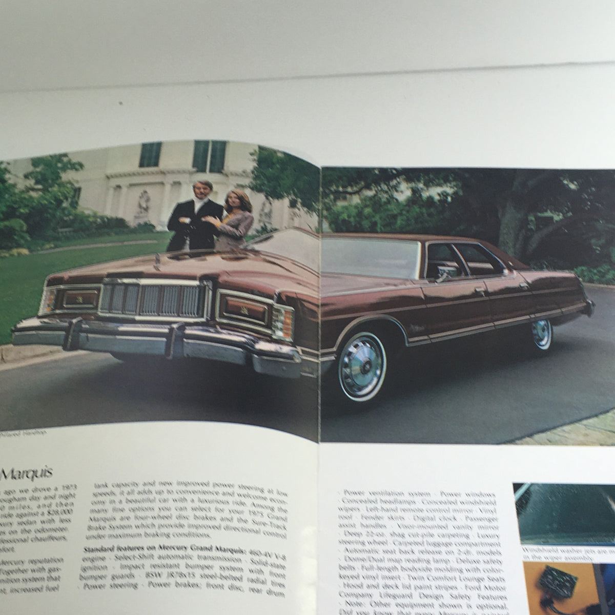 Interior spread of the 1975 Ford Mercury Grand Marquis/Cougar XR-7 Dealership Car Auto Brochure Catalog showcasing a red Mercury Grand Marquis with a couple standing beside it.