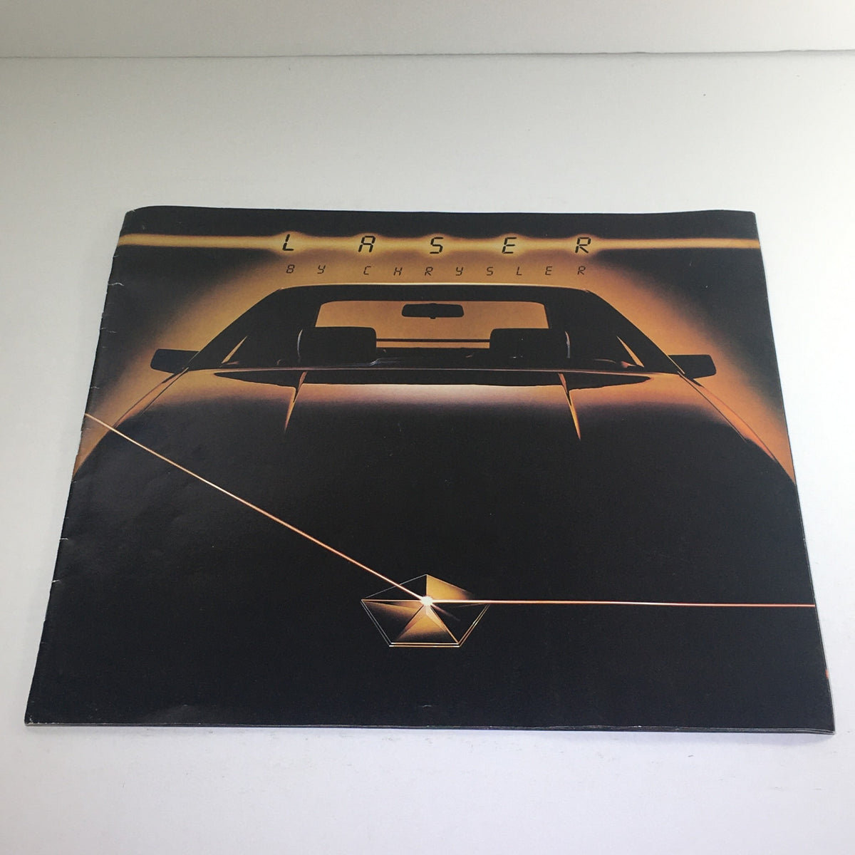 Cover of the 1984 Laser XE by Chrysler Form #81005-40011 auto brochure catalog featuring a sleek car design.