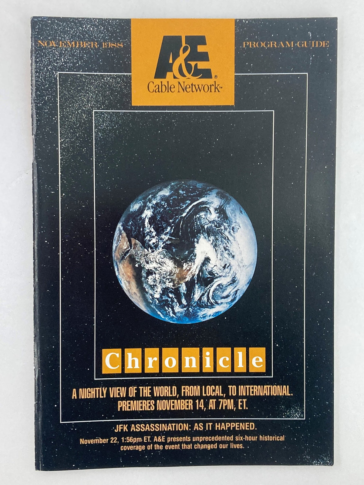 Vintage A&E Cable Network Program Guide from November 1988 featuring the JFK Assassination. The cover displays a cosmic background with Earth, showcasing the title 'Chronicle' and detailing the program's historical significance.